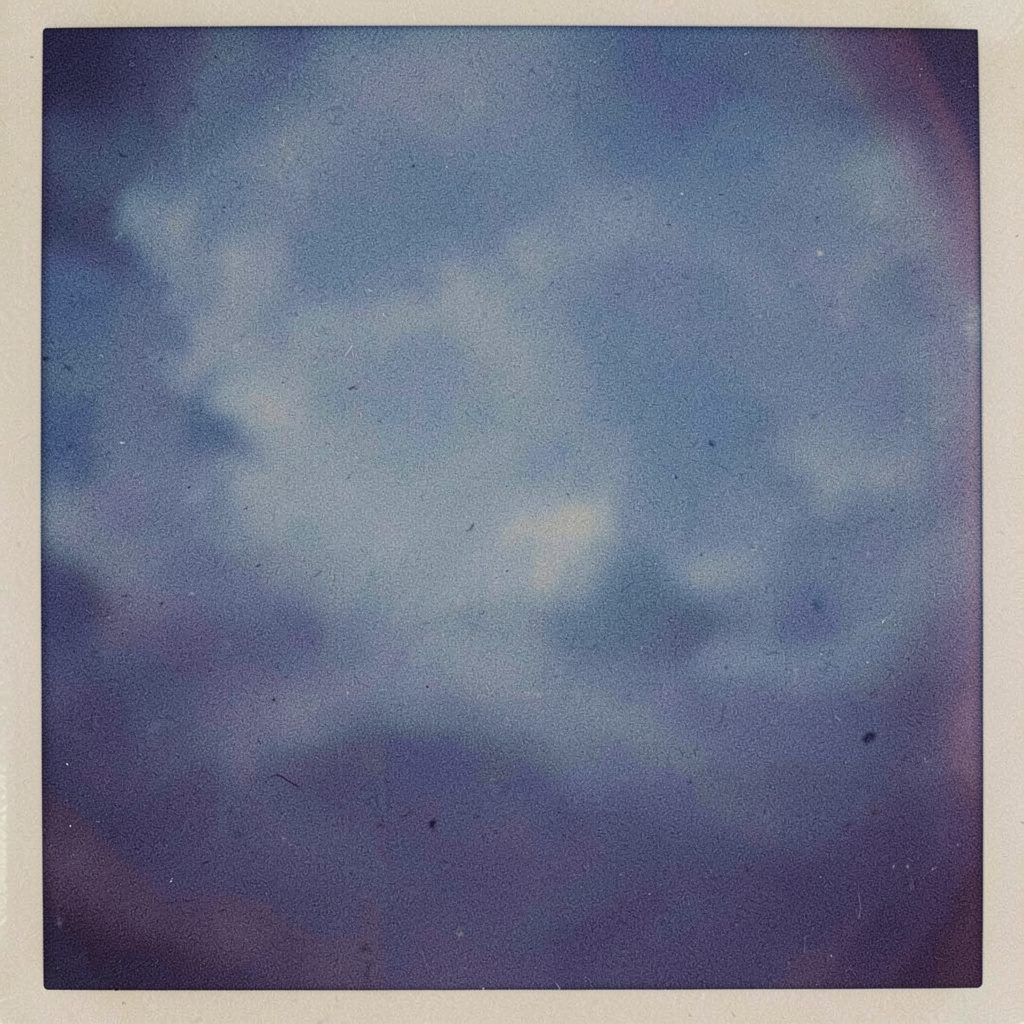 Analog film photograph of hands reaching into a sensory bin, soft daylight.